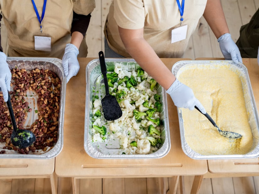 volunteers in soup kitchen handing out food