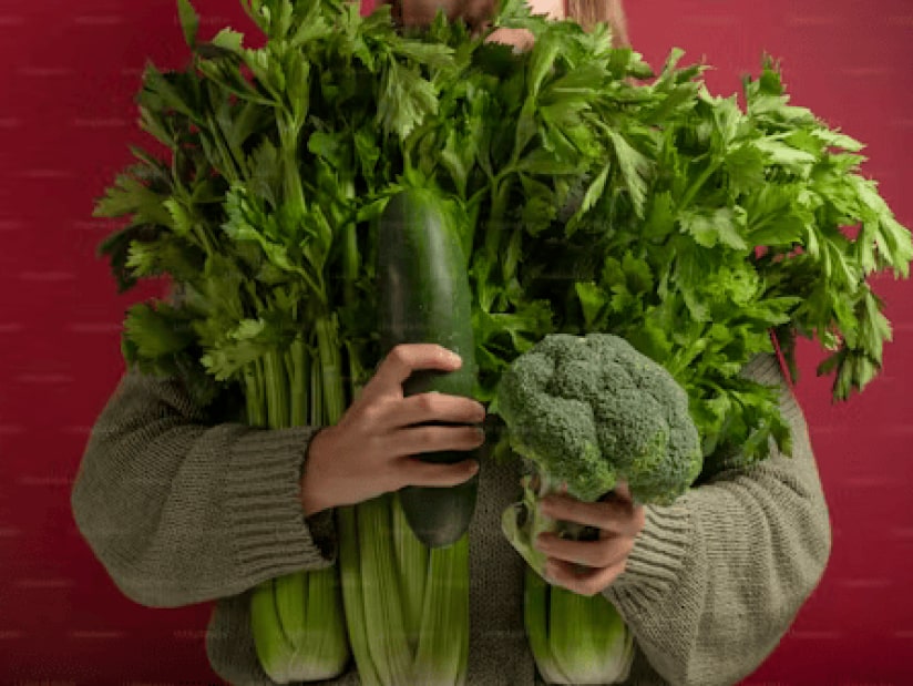 person holding letus, squash and broccoli in arms