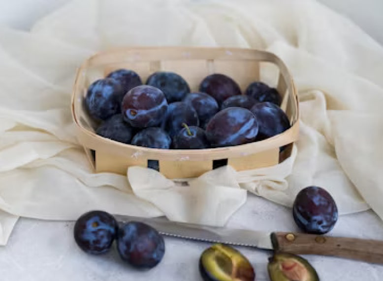 Plums in basket on a table