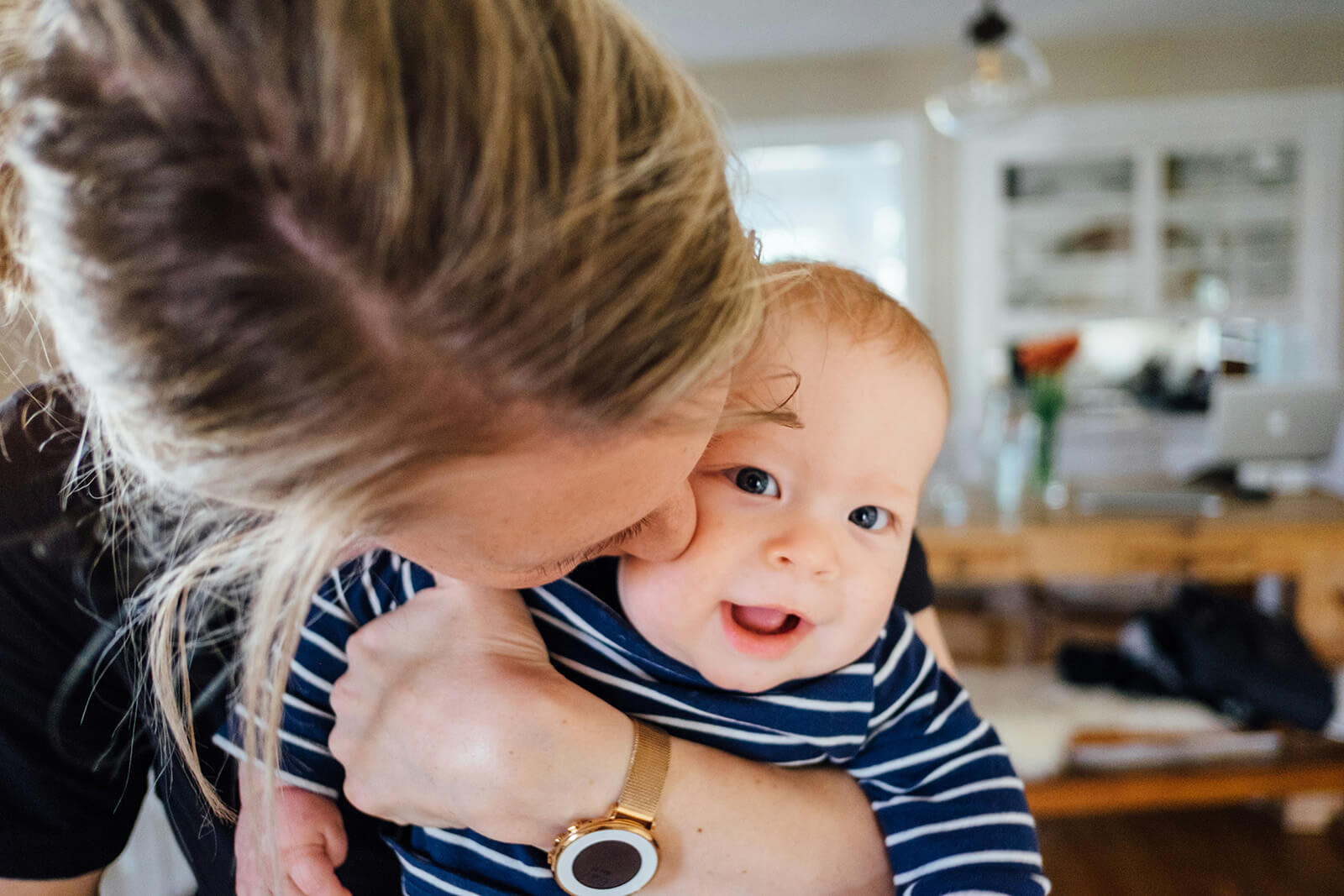 parents kissing their baby on the cheek