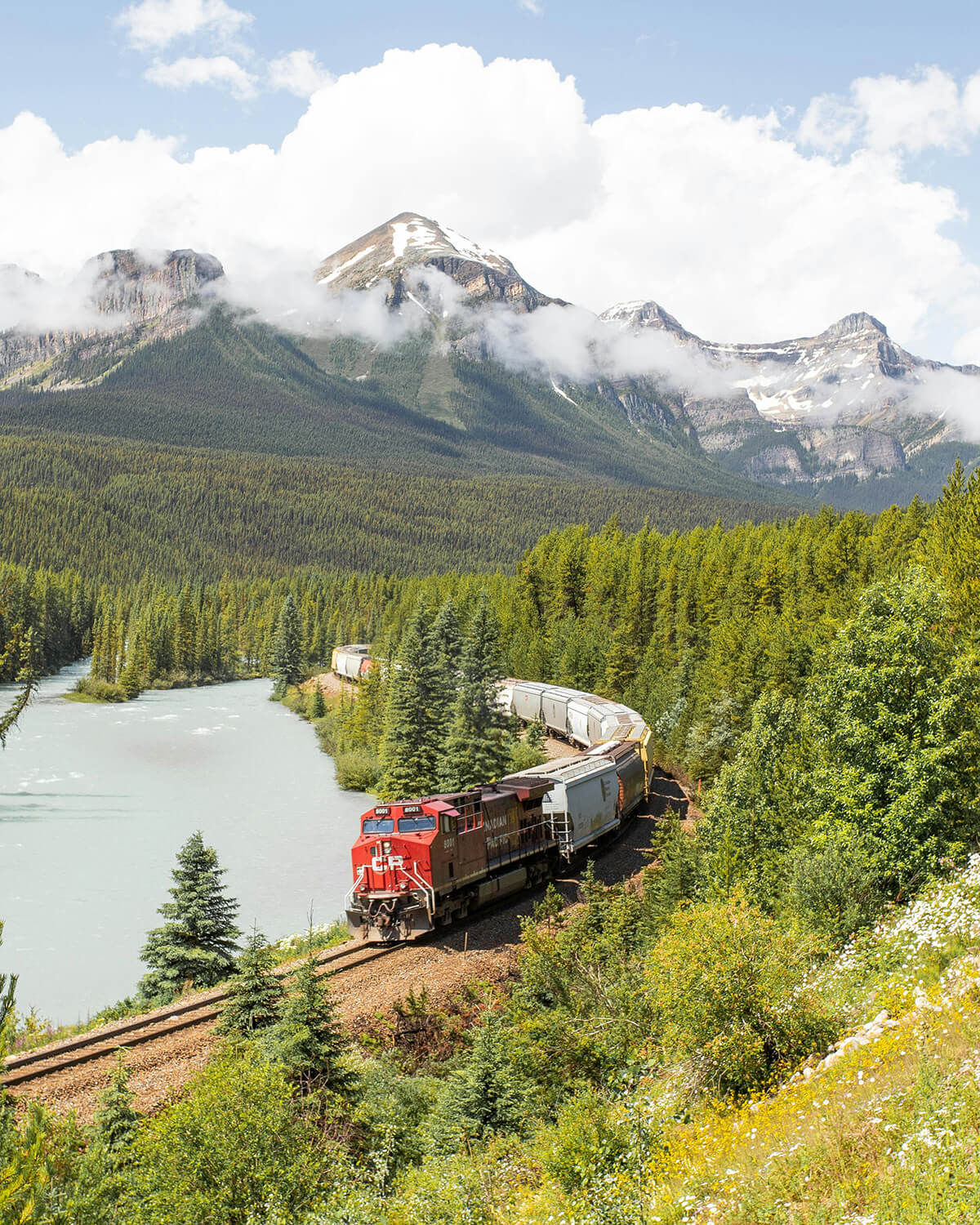 train in a mountain, lake and forest scene delivering food