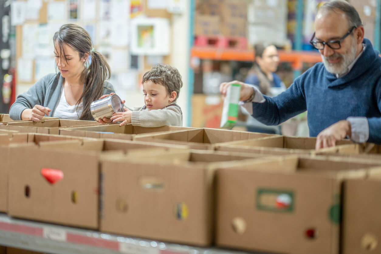 boxes of assorted food with people in need picking out items of food to take